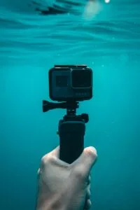 Underwater camera held by a hand, showcasing the latest travel gadgets for adventures.